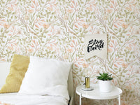 Watercolor green leaf wallpaper in a bedroom corner with a white side table.