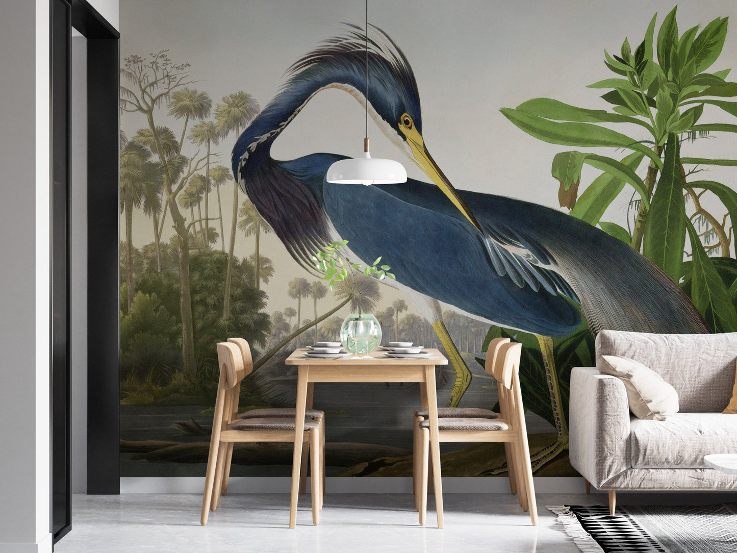 Tropical green leaf wall mural with a heron in a compact dining area with wooden chairs.