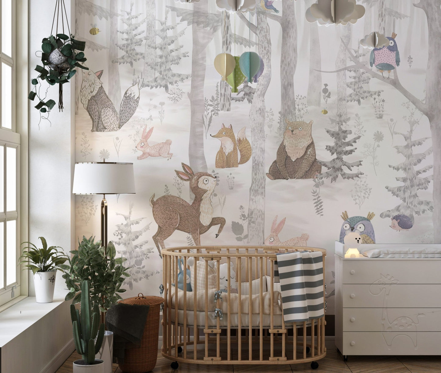 Infant nursery featuring a cot and a full wall animal forest wall mural.