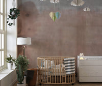Nursery room with light beige wall mural and wooden crib under hanging decor.