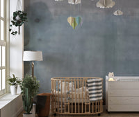 Nursery room featuring a light blue watercolor wall mural design.