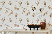 Cream and brown monkey print wallpaper behind a dining table with ceramic decor.