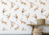 Playful monkey repeat pattern wallpaper behind a wooden bench and baskets.