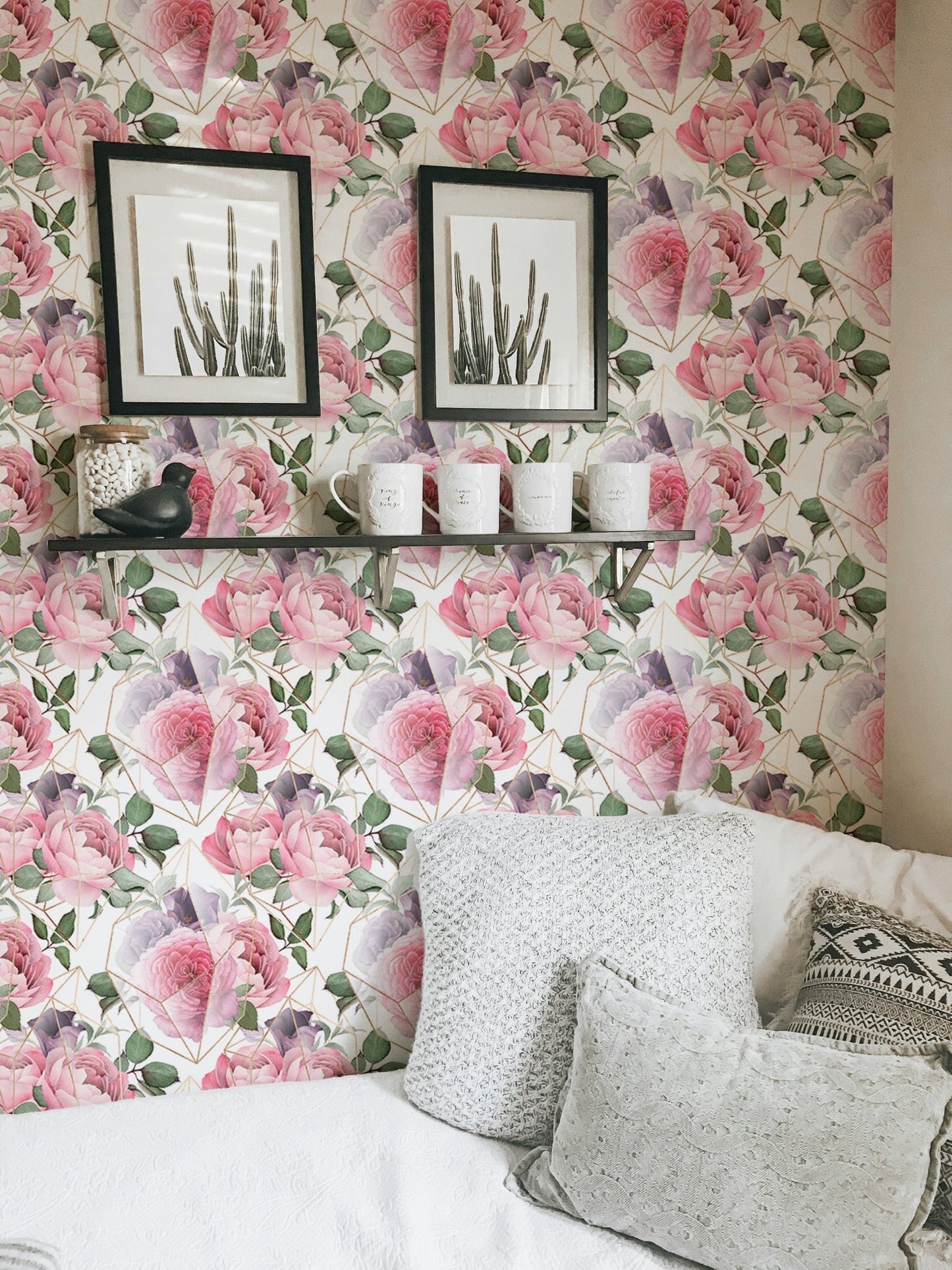 Pink floral wallpaper in a living room with grey pillows and framed art.