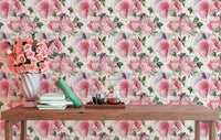 Pink flower wallpaper in a workspace with a wooden table and pink vase.