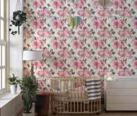 Nursery room featuring pink flower wallpaper and wooden crib.