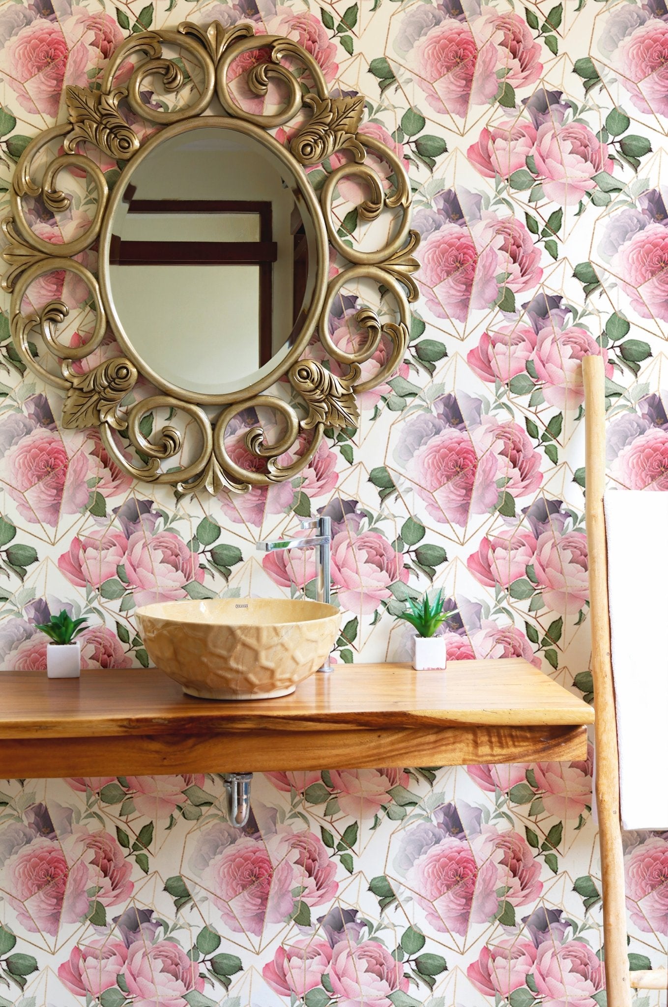 Decorative gold line floral wallpaper behind a round gold mirror.