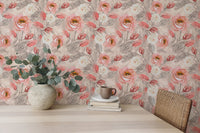 Watercolor flower wallpaper on a study wall with a light wood desk and green plant.