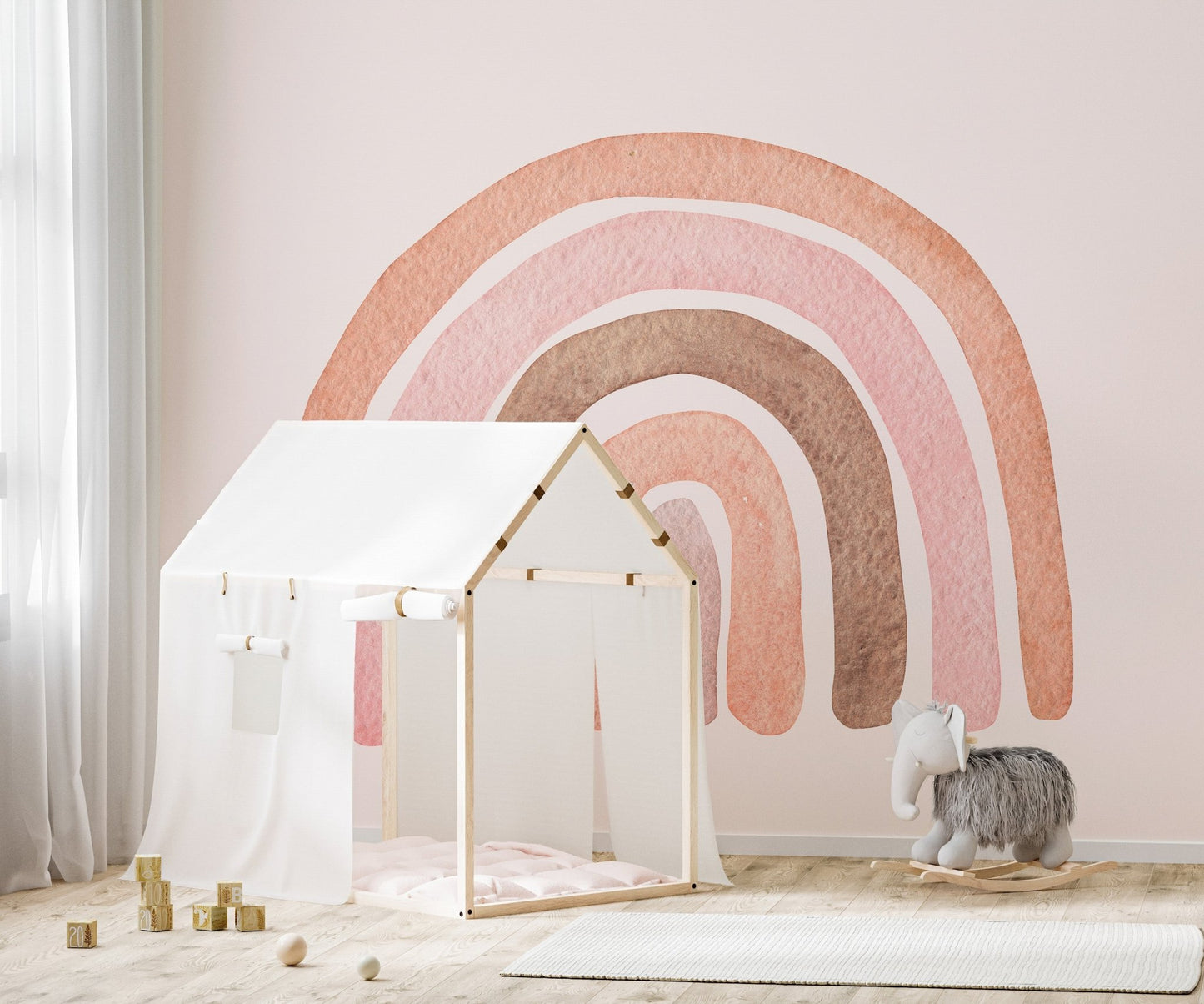 Pink watercolor wall mural featuring earth tone arches behind a white toy tent in kids room.