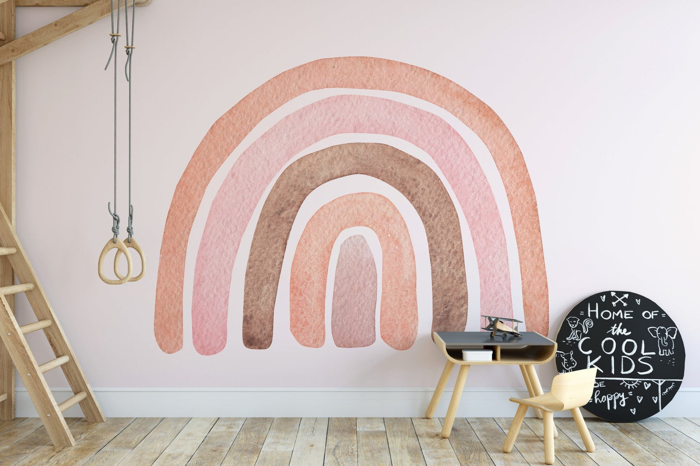 Hand-painted style rainbow wall mural behind a wooden desk and chair.