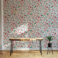 Pink floral wallpaper in a workspace with a wooden desk and potted plant.