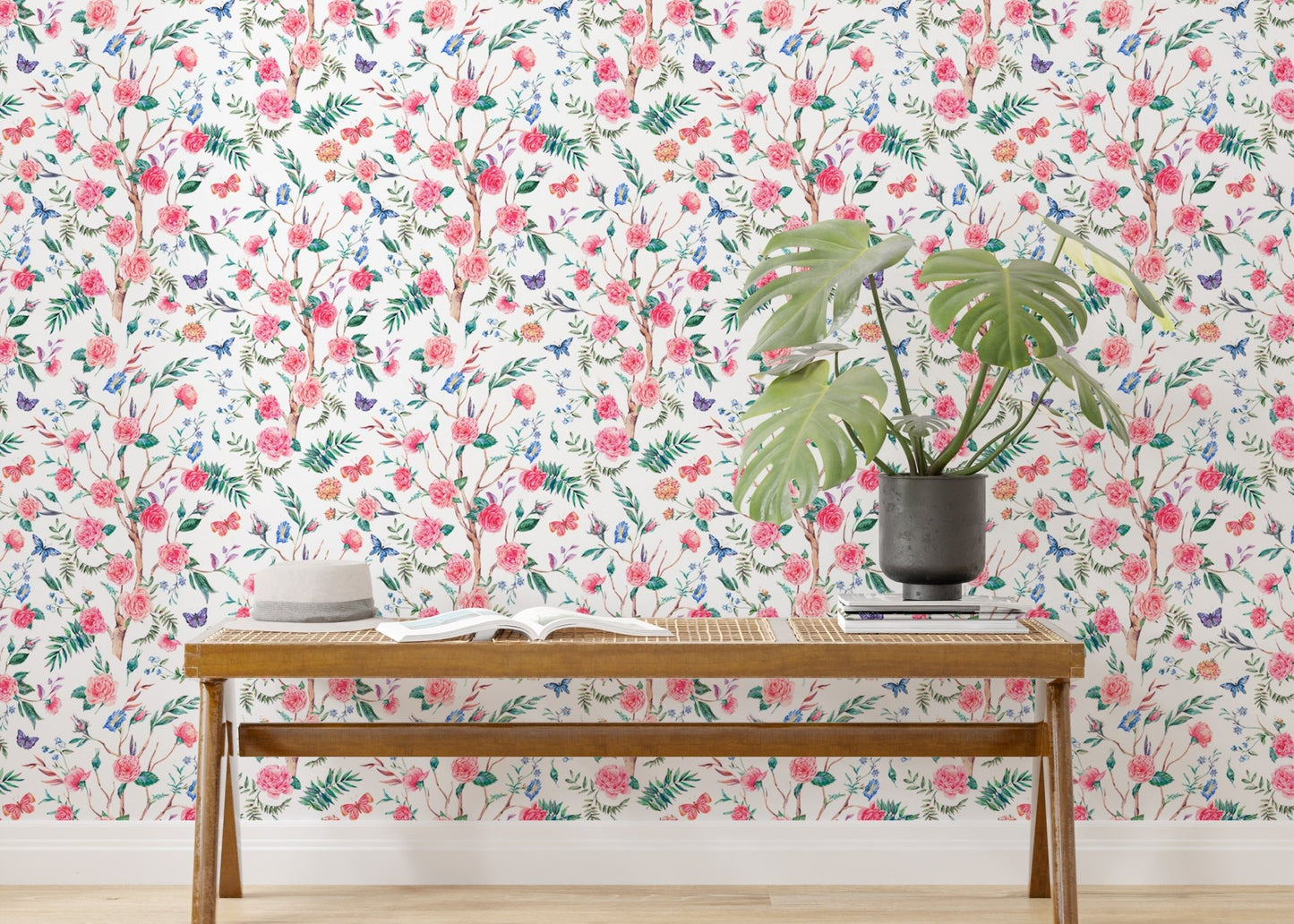 Floral wallpaper with green leaves and pink buds behind a long wooden bench.