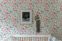 White floral wallpaper in a child's room above a white wooden crib.