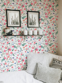 Watercolor Rose Bouquet Blooming White Floral Wallpaper behind a shelf with frames.