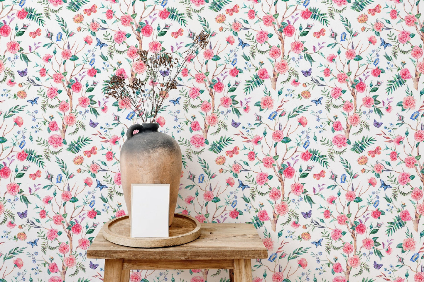 Blooming rose wallpaper behind a wooden stool with a ceramic vase.