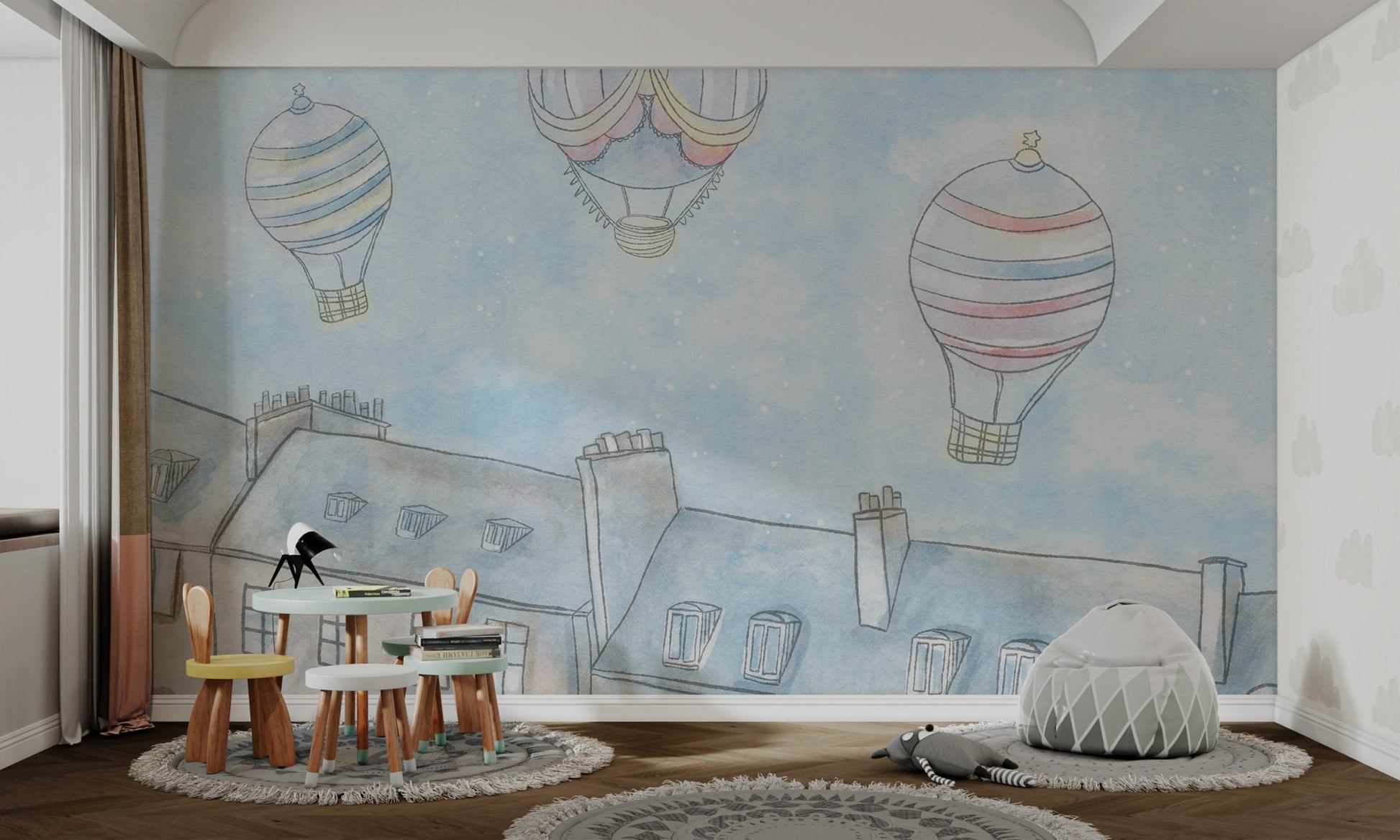 Muted pink and yellow striped balloon on light blue wall mural in nursery.