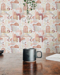 Coffee mug on a table in front of warm pastel aesthetic wallpaper.