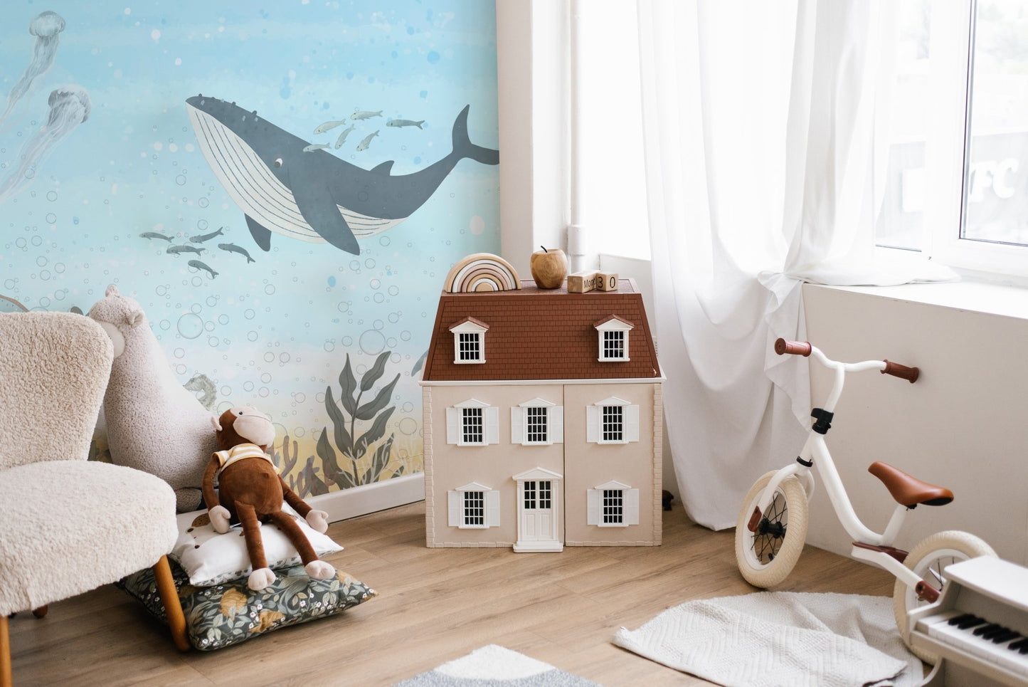 Illustrated whale wall mural with bubbles and sea creatures.