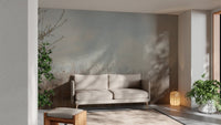 Neutral tone reeds wall mural behind a grey sofa in a sunlit living room.