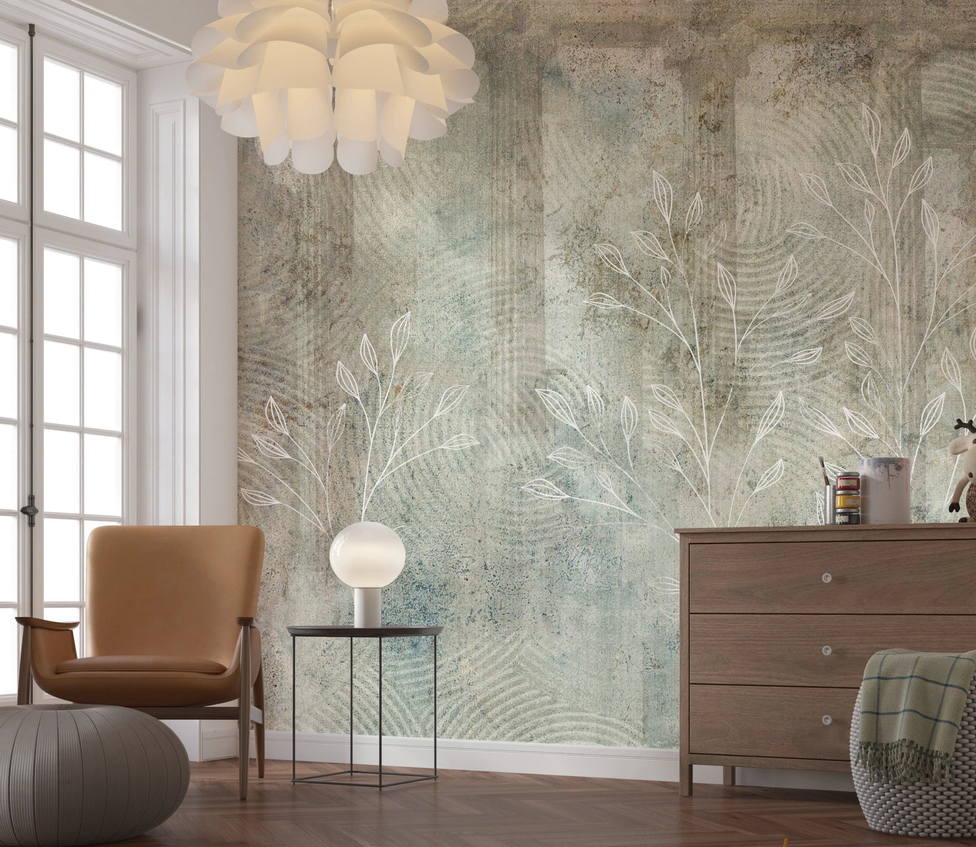 Sage green and grey whisper wall mural behind a leather chair and wooden dresser.