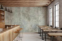 Whisper inspired wall mural in a sunlit lounge with potted plants.