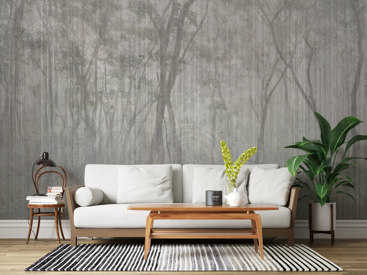 White sofa and green plants set against a grey woodland wall mural
