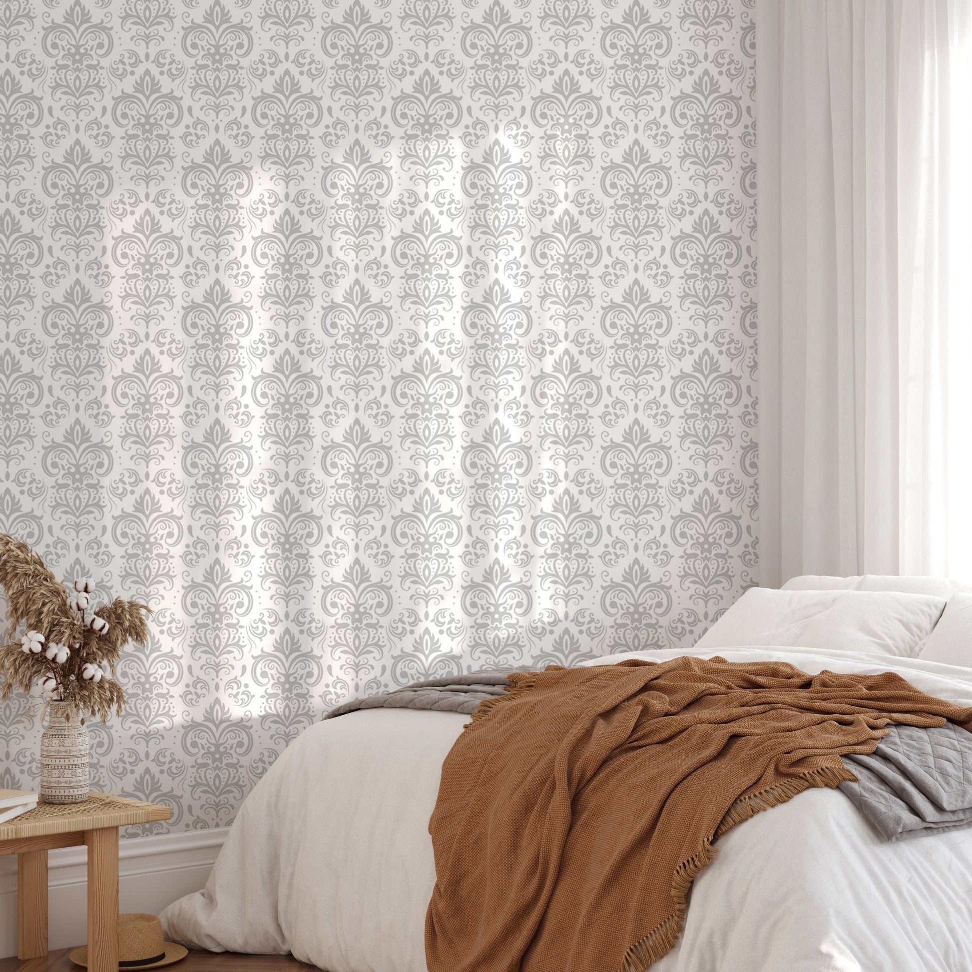 Bedroom wall mural with damask print and a bed with a brown throw blanket.