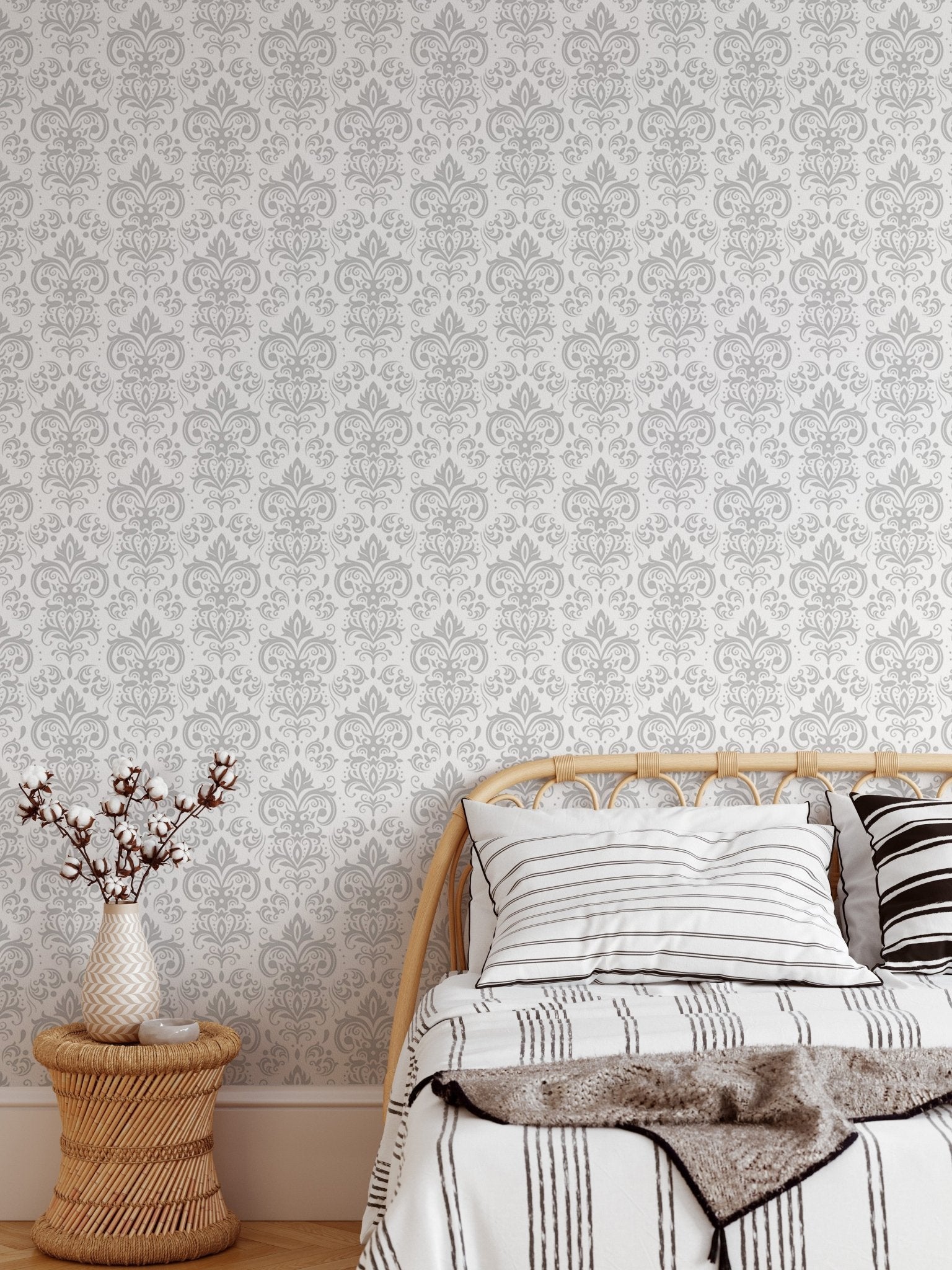 White and grey damask wall mural in a bedroom with a wooden side table and bed.