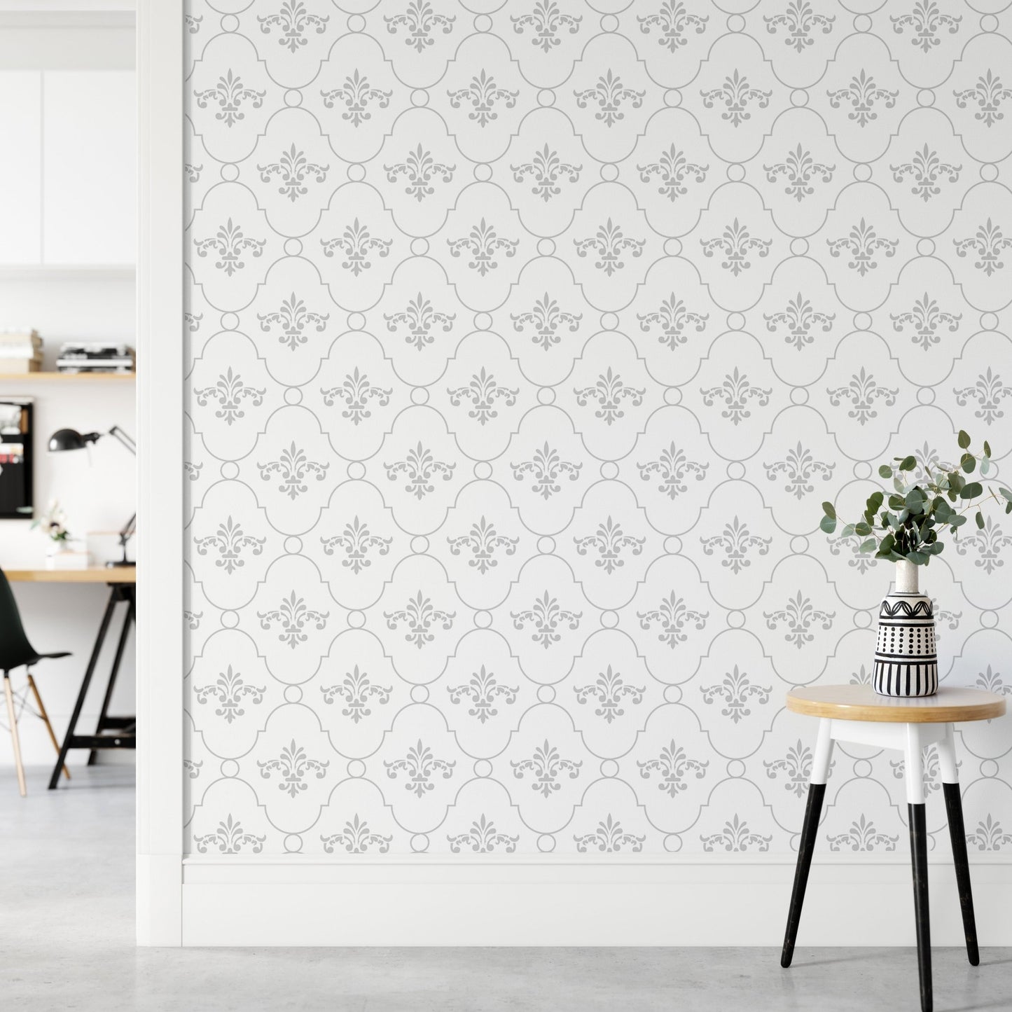Vintage damask wallpaper behind a small side table and potted plant in a living area.