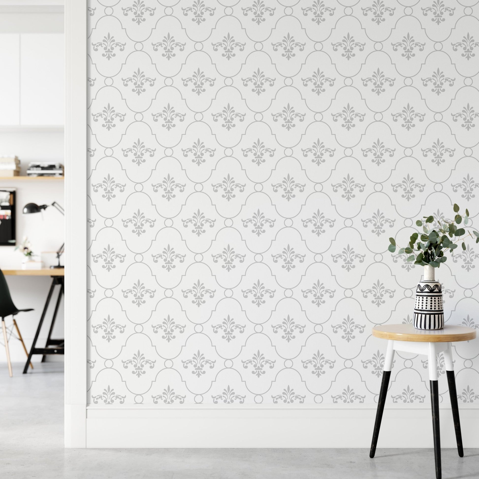 Vintage damask wallpaper behind a small side table and potted plant in a living area.