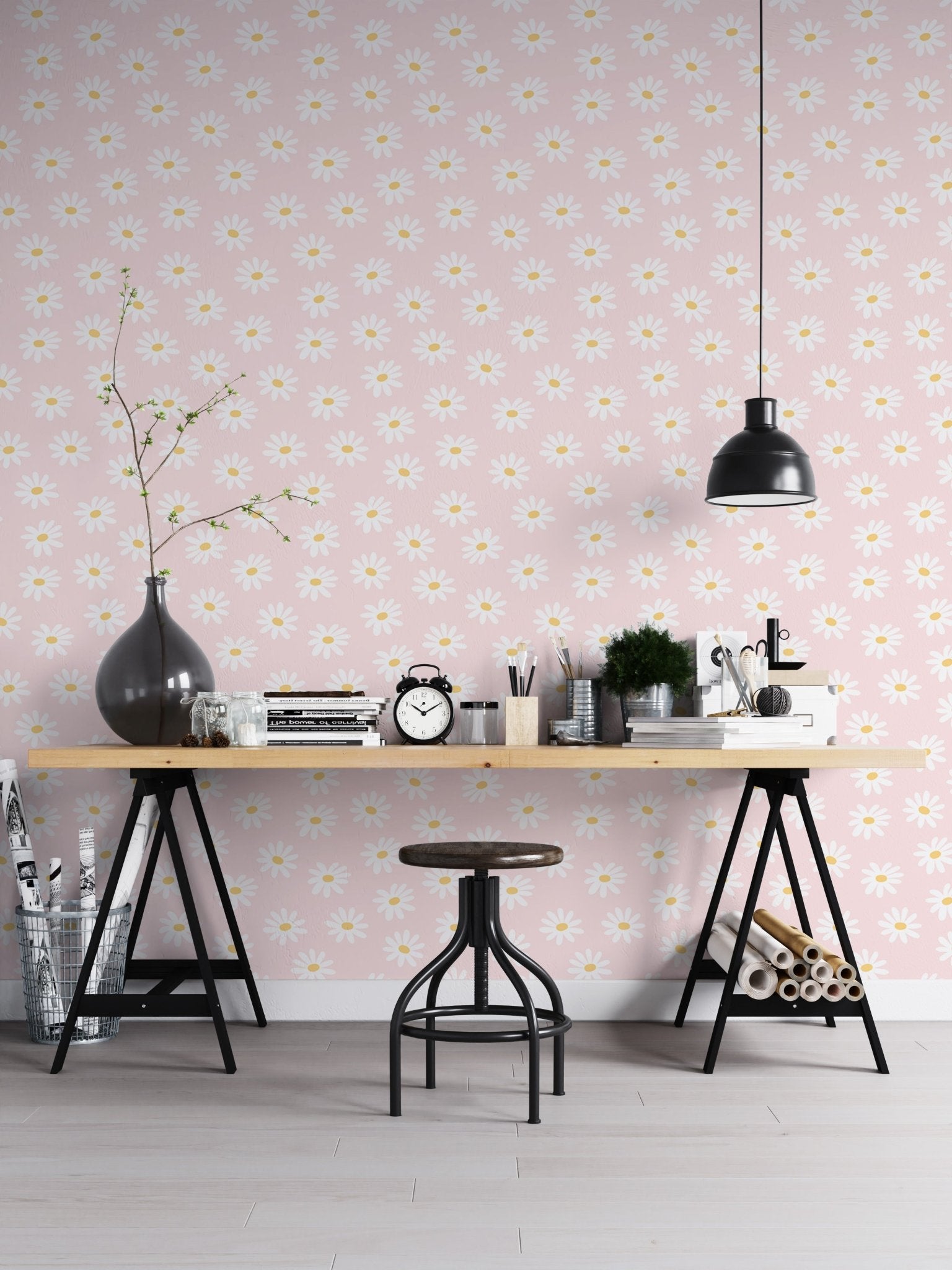 Workspace with a wooden desk and black lamps against a pink floral wallpaper.