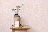 Wooden stool with a vase of dried flowers against flower wallpaper.