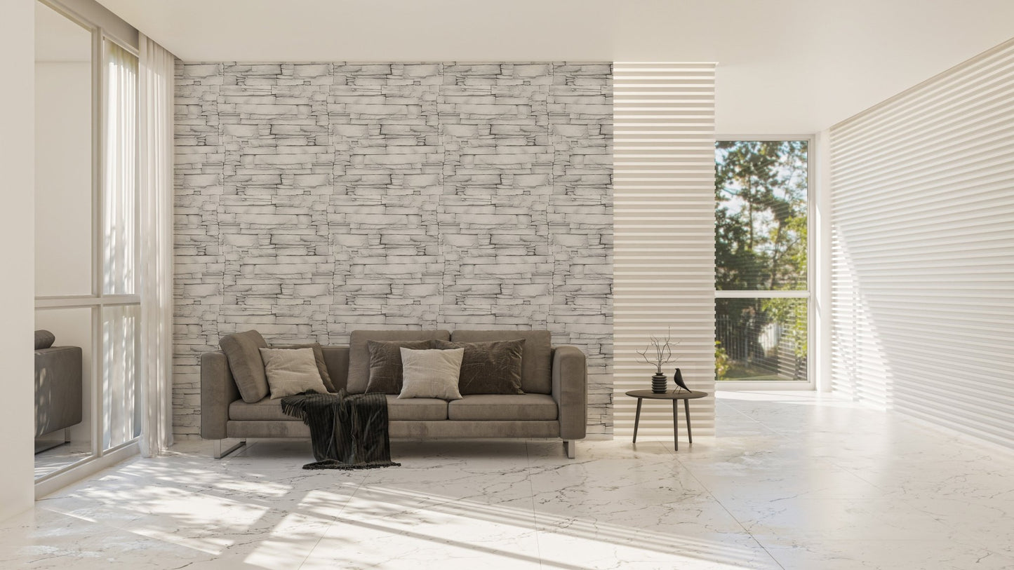 Large living space with a grey sofa and a white stone texture wallpaper.