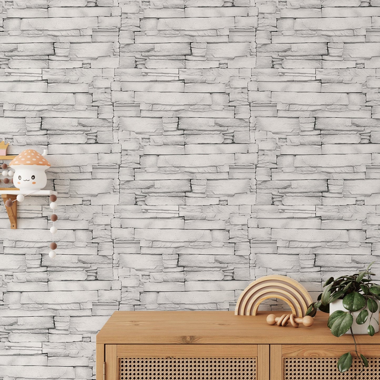 White color limestone masonry wallpaper behind a light wood sideboard with decor.