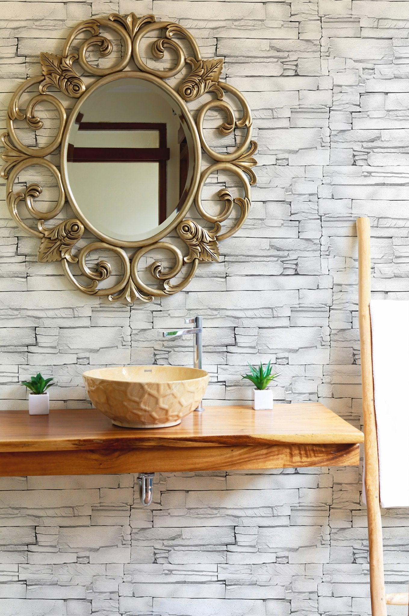 Decorative masonry wallpaper in a hallway featuring a gold ornate mirror.
