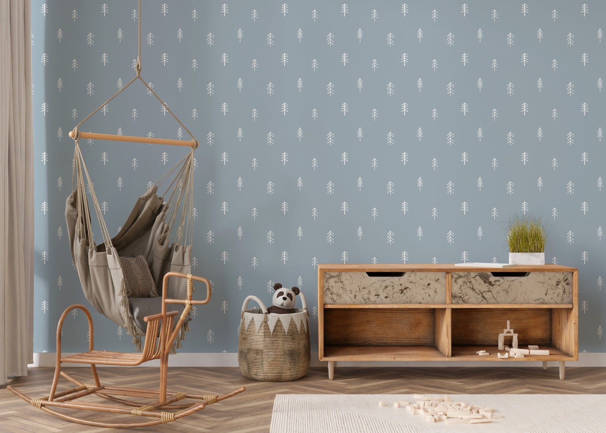 Pine tree wallpaper on feature wall with hanging chair and wooden console.