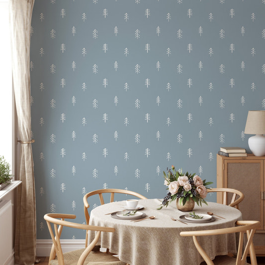 White pine tree wallpaper on blue wall in dining room with round table.