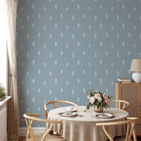 White pine tree wallpaper on blue wall in dining room with round table.