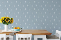 Simple white tree wallpaper in bright dining space with yellow flowers.