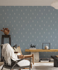 Pine tree pattern wallpaper in living room with black chair and side table.