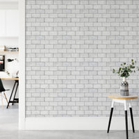 Minimalist hallway with white brick wallpaper and a wooden stool.