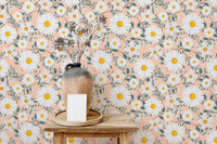 Floral branch wallpaper in a room with a wooden table and vase.