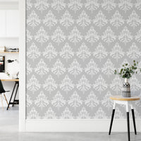 Patterned grey wallpaper next to a white door frame and wooden side table.