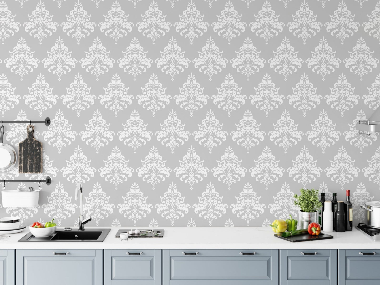 Floral damask wallpaper installed behind a white kitchen counter with grey cabinets.