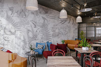 Intricate bird and fox illustrations on a grey woodland wall mural in cafe.
