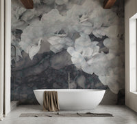 Grey and white floral mural behind a freestanding bathtub in a washroom.