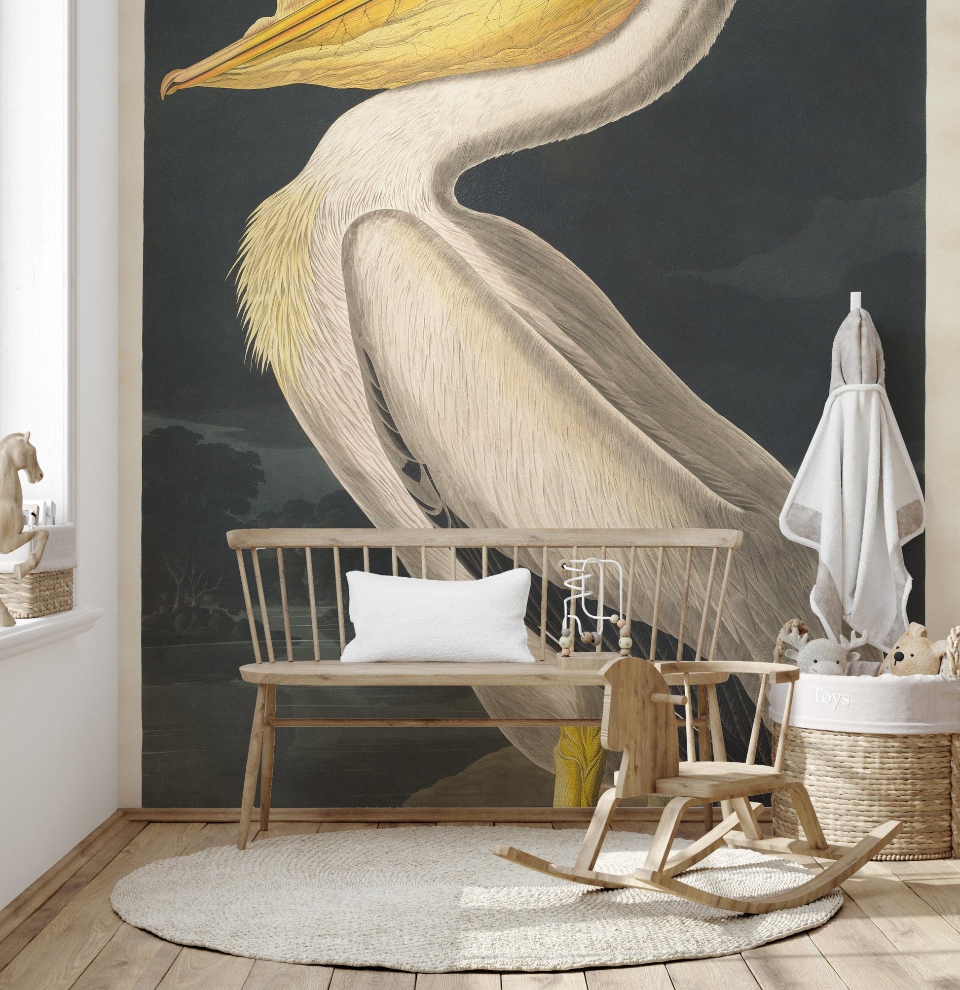 Nursery area showing a pelican wall mural behind a wooden bench.