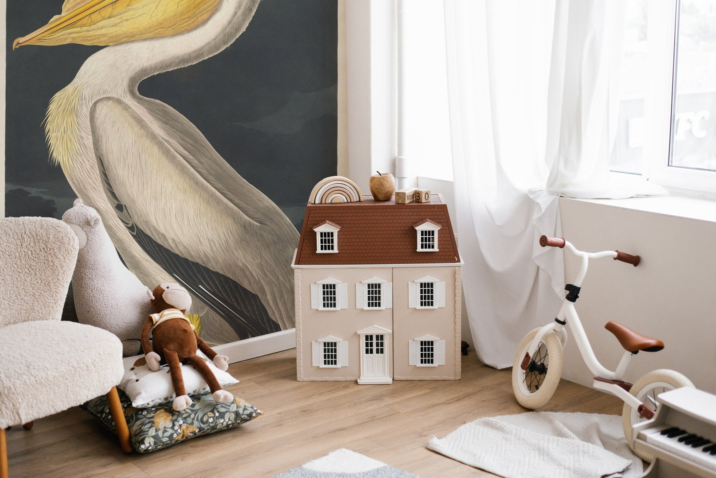 Kids playroom featuring a bird wall mural and wooden dollhouse.