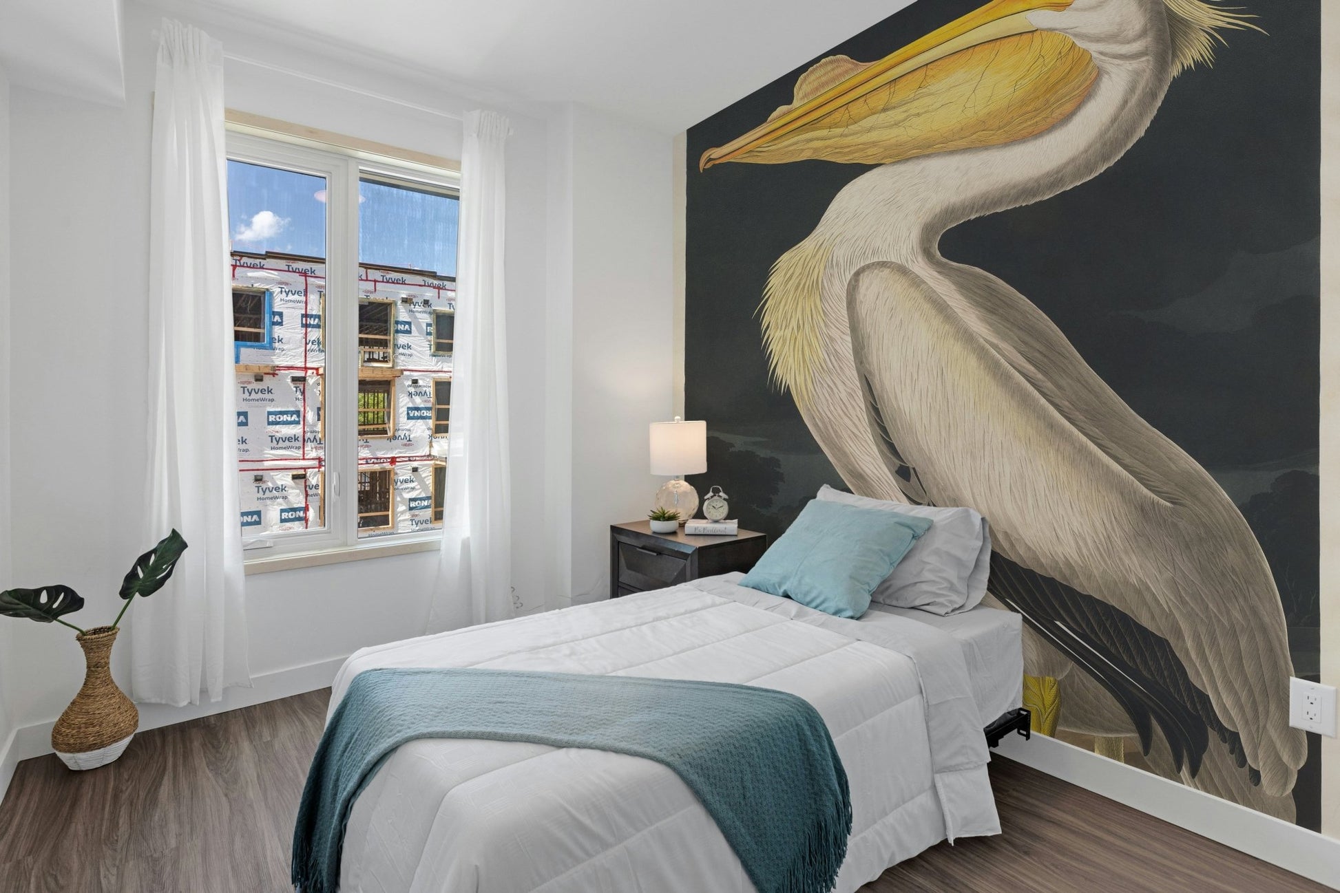 Minimalist bedroom with White Pelican Bird Wall Mural and blue bedding.