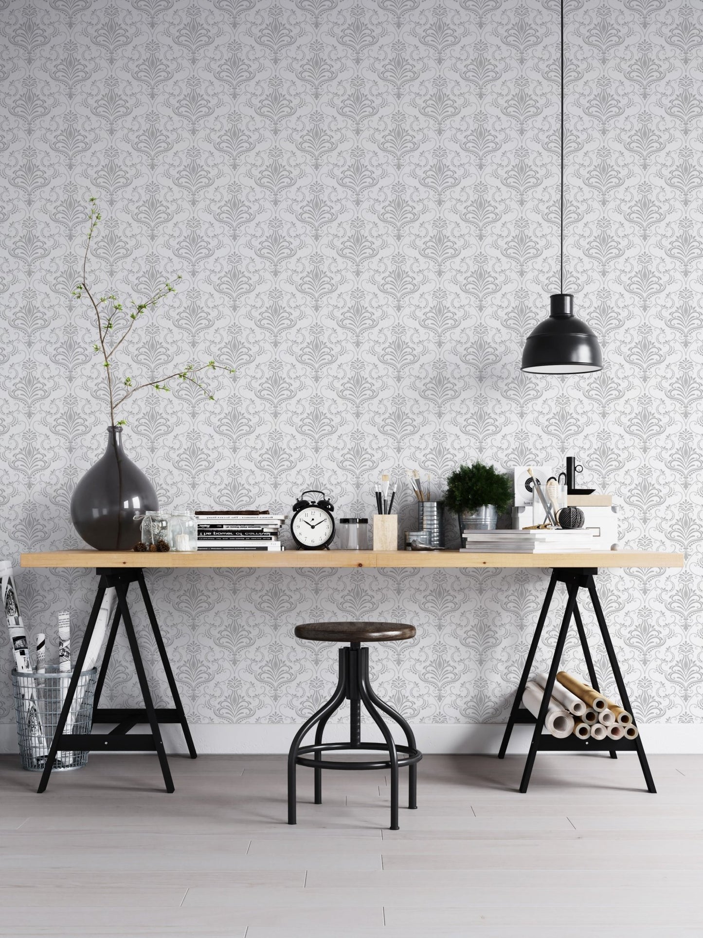 Office workspace with white damask wallpaper behind a black metal desk.